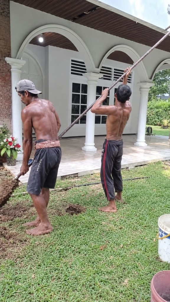 Pekerja mengangkat tanah hasil pengeboran strauss pile manual